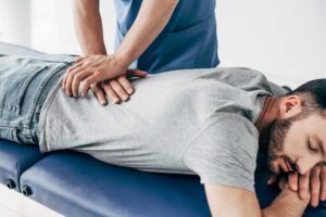 A middle-aged person gently stretching their neck at home in a comfortably lit living room.